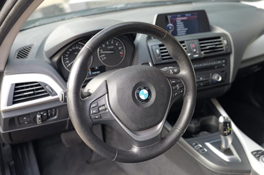 BMW 1-serie 116i Business AUT|Cruise C|LM velgen|Navi|Trekh, Euro 5, Gebruikt, Zwart, 4 cilinders