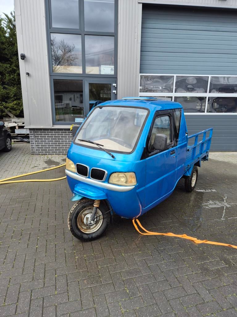 Blauwe driewieler met motor en kenteken, Ophalen