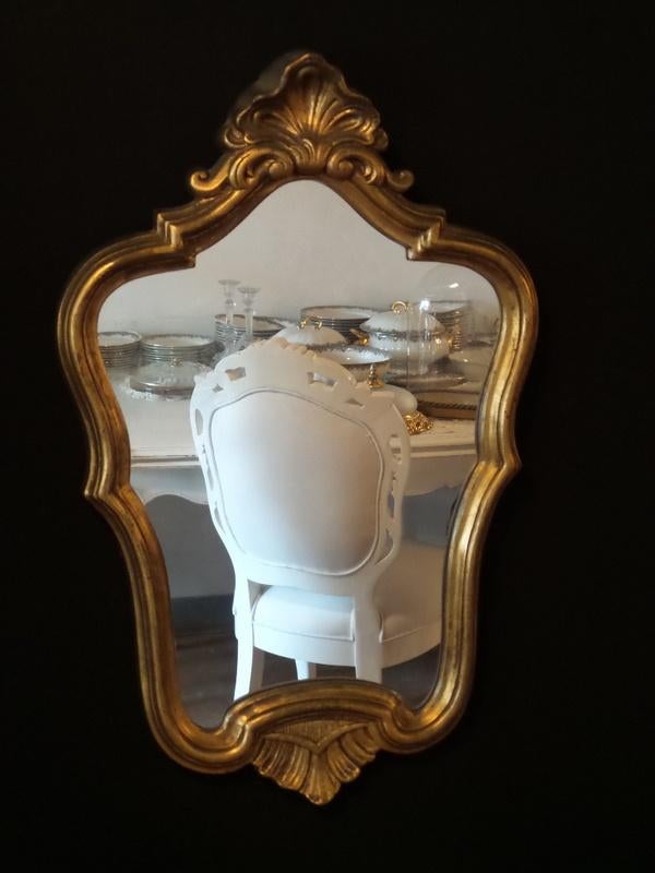 Sierlijke spiegel met kuif en heeft een houten goude lijst