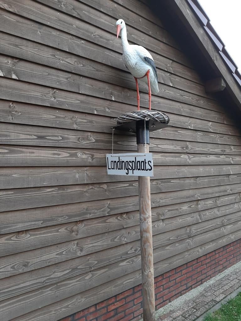 Ooievaar op nest met paal en pop en bordje landingsplaats, Ophalen