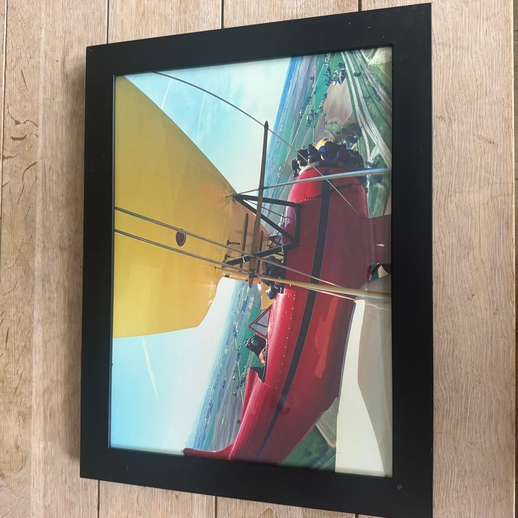 Ingelijste foto van een rood vliegtuig in de lucht, Huis en Inrichting, Woonaccessoires | Schilderijen, Tekeningen en Foto's, Ophalen of Verzenden