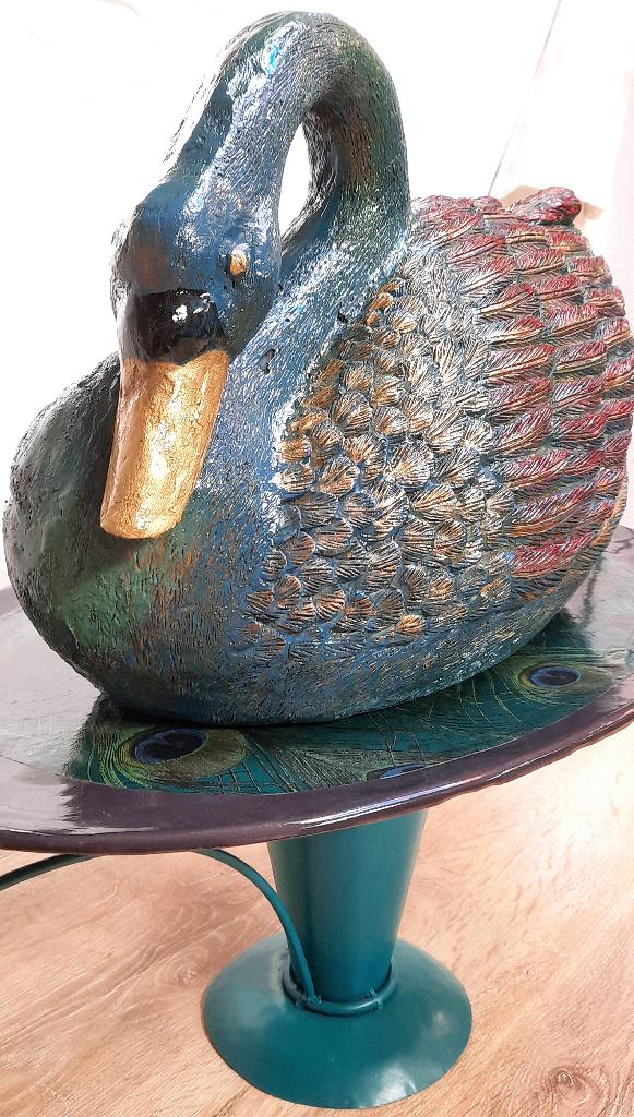 sierlijke zwaan op metalen schaalschaal, Ophalen