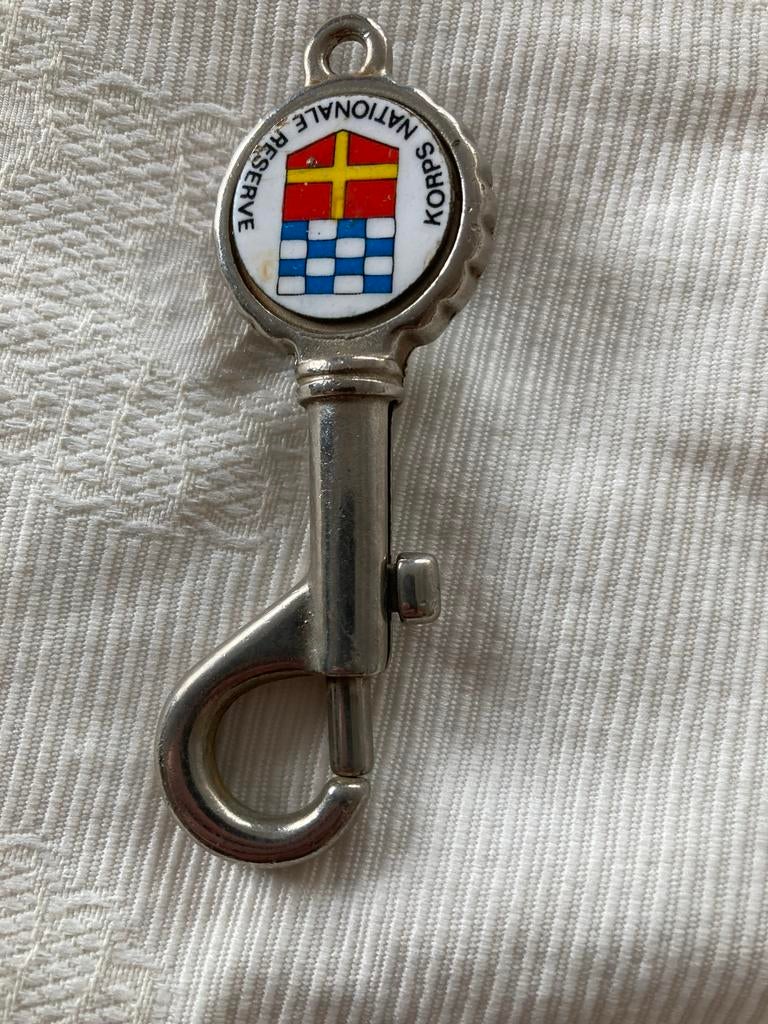 Korps Nationale Reserve sleutelhanger (Flesopener), Verzamelen, Militaria | Algemeen, Verzenden, Landmacht, Nederland, Overige typen