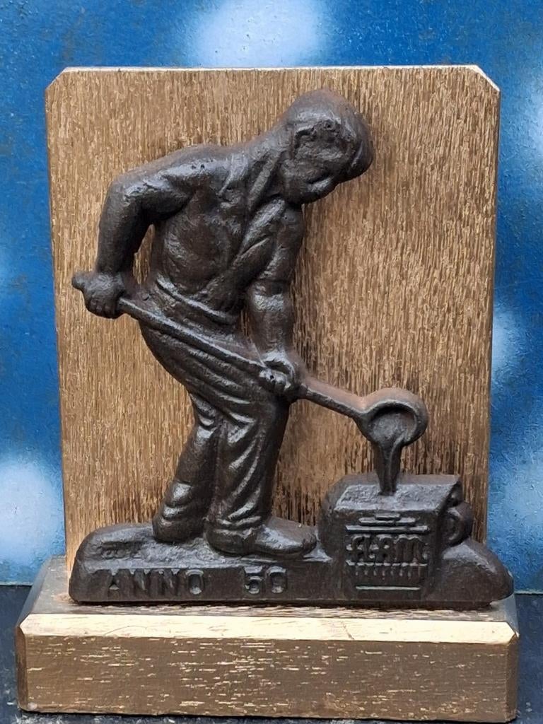 Ijzergieter. Plaquette. Metaal.  Houten sokkel.  18 cm., Ophalen, Zo goed als nieuw