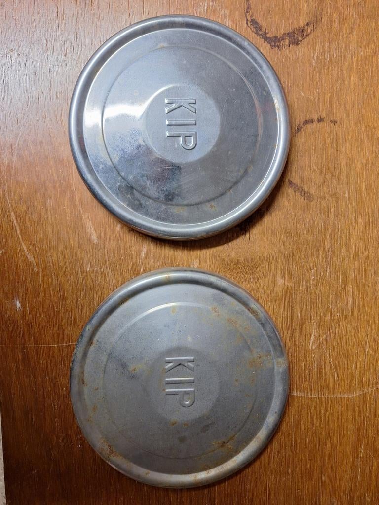 Twee metalen wieldoppen met 'KIP' erop, Ophalen