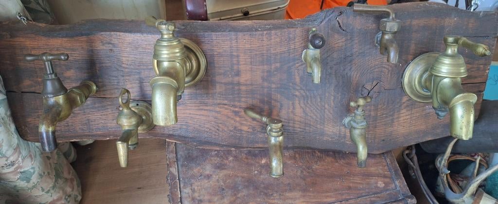 Antieke koperen kranen op houten plank - decoratie, Ophalen