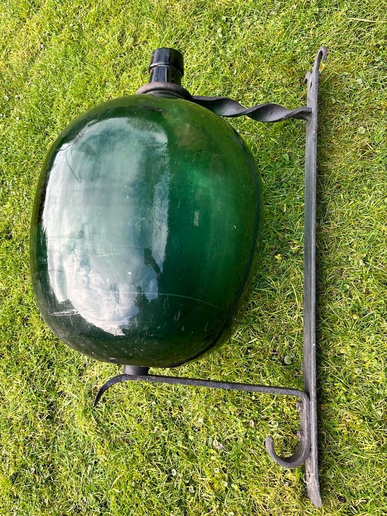 Dame Jeanne gistfles met smeedijzeren wandhouder, Ophalen