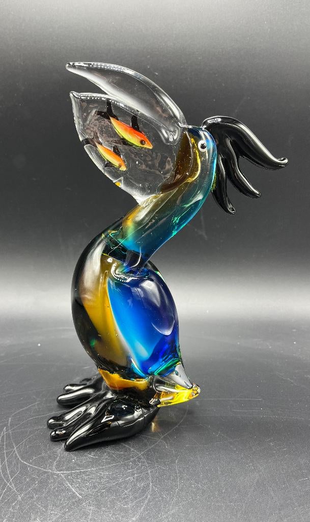 Pelikaan van glas met vissen in zijn bek.